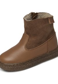 Botas de tobillo marrones con una puntera de cuero liso y una parte superior de ante suave, que cuentan con un forro de felpa y una suela texturizada marrón.