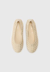 Μπεζ μπαλαρίνες από μαλακό υλικό, με χρυσά καρφάκια, στρογγυλεμένη μύτη και επένδυση με μαξιλάρι και οπές για διαπνοή.