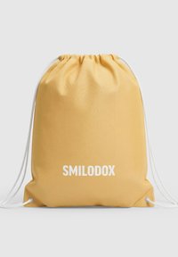Bolsa amarilla con cordón hecha de material duradero, con una textura suave y el logotipo blanco "SMILODOX" impreso en el frente.