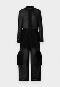 Crna prozirna kombinezona s kariranim izrezom, prednjim dugmadi, elastičnom strukom i velikim kenguruf žepovima sa strane.