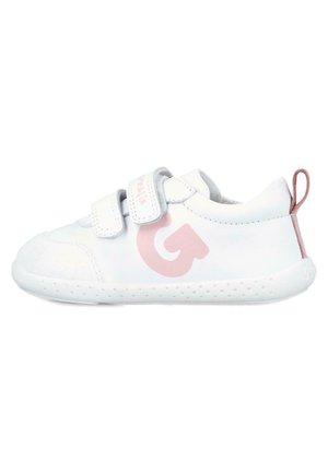 Zapatilla blanca con parte superior texturizada, dos correas de Velcro, un logo gráfico en rosa en el costado y una suela de goma con pequeñas perforaciones.