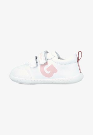 Zapatilla blanca con parte superior texturizada, dos correas de Velcro, un logo gráfico en rosa en el costado y una suela de goma con pequeñas perforaciones.