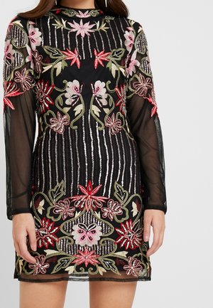 Czarna, prześwitująca sukienka z długim rękawem, ozdobiona szczegółowym czerwonym, różowym i zielonym haftem kwiatowym oraz pionowymi pasami.