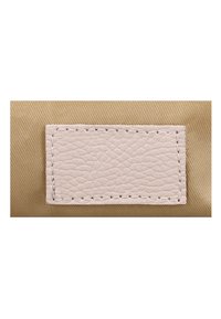 Ruuduline beež nahast lapik, millel on tekstureeritud pind, õmmeldud helepruuni niidiga tan värvi kangale.