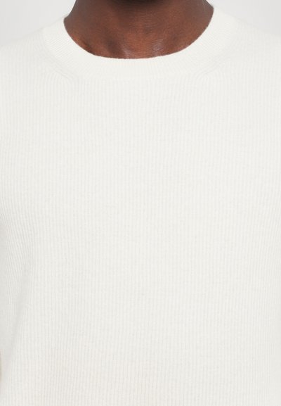 White ribbed knit sweater featuring a classic crew neckline and a smooth texture. Simple design, no visible patterns or hardware.