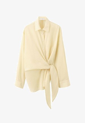 Gelbes Wickelshirt mit Kragen, langen Ärmeln und dezenten vertikalen Streifen, das mit einer gebundenen Detail am Taillenbereich gesichert wird.