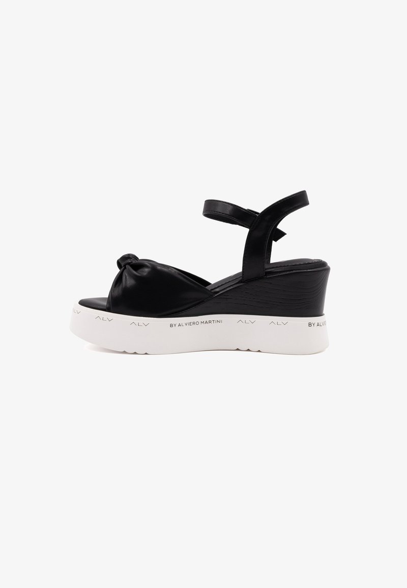 Schwarze Keilsandalen mit einem geknoteten Vorderdesign, synthetisches Obermaterial, verstellbarer Knöchelriemen und einer weißen strukturierten Plattformsohle.