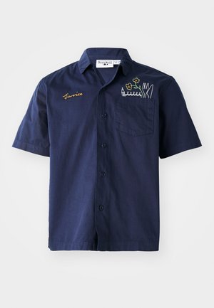Marineblauwe katoenen shirt met korte mouwen. Voorzien van een knoopsluiting, een borstzak met bloemen- en potloodborduursel, en "Service" in goud geborduurd.