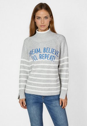 Grauer Pullover mit weißen Streifen, hohem Kragen und Bündchen in Rippenstruktur. Gestickter Text in Blau lautet: "TRÄUME. GLAUBE! TUE. WIEDERHOLE!"