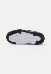 Black and white athletic shoe sole with textured rubber, circular tread pattern, and "JORDAN" embossed on the midsole.