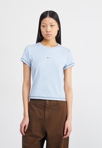 T-shirt de manga curta azul clara feita de algodão com golas redondas, apresentando um pequeno logotipo preto da Nike ao centro e costura de bainha contrastante.