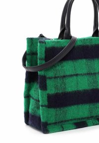 Sac à main rectangulaire en feutre à carreaux verts et noirs avec des anses en cuir noir et une bandoulière amovible.