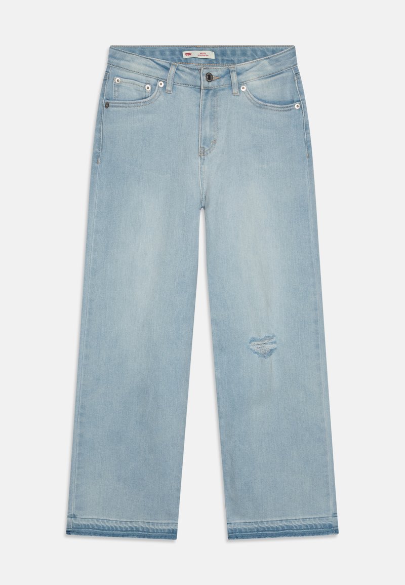 Jeans en denim bleu clair à jambes larges avec un patch déchiré, conception à cinq poches, rivets en métal et fermeture à bouton à la taille.