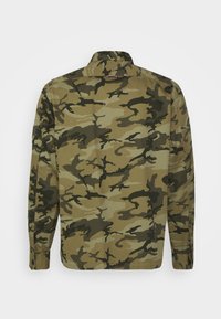 Camicia a maniche lunghe con stampa mimetica in tonalità di verde e beige. Presenta un colletto, polsini con bottone e dettaglio sulla spalla posteriore. Materiale in cotone.