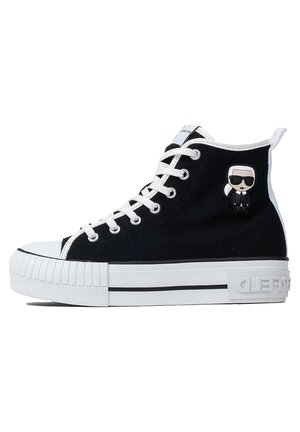 Czarny wysoki sneaker z białymi sznurówkami i podeszwą, z małą postacią z kreskówki z okularami przeciwsłonecznymi przymocowaną z boku.