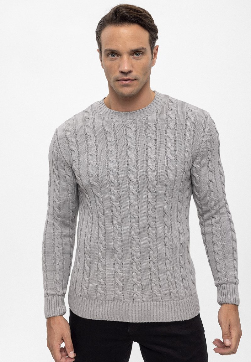 Hellgrauer Strickpullover mit rundem Halsausschnitt, gerippten Bündchen und Saum sowie einem strukturierten Muster auf der Oberfläche.