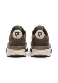 Sneakers in camoscio marrone con una suola in gomma beige, caratterizzati da un contrafforte testurizzato e un logo sul retro, progettati per comfort e durata.