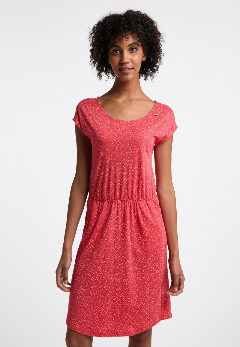 Robe rouge à manches courtes avec un col arrondi et une taille élastique. Présente un motif à pois et un petit bouton décoratif près du décolleté.