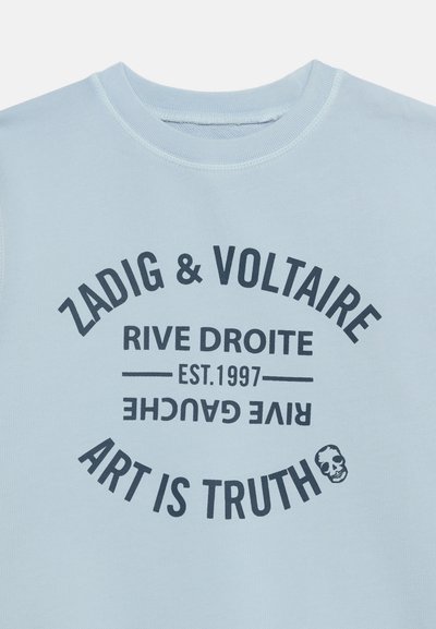 Hellblaues Sweatshirt mit schwarzem Text in kreisförmigem Muster: „Zadig & Voltaire“, „Rive Droite“, „Est. 1997“, „Rive Gauche“ und „Art is Truth“ mit einer kleinen Totenkopf-Grafik.