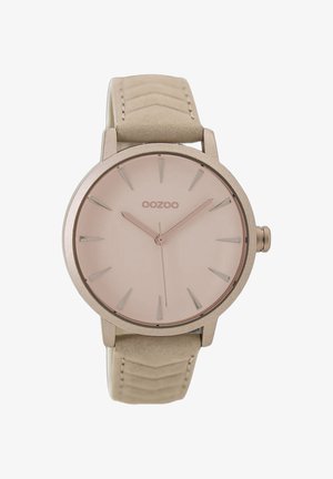 Montre ronde avec un boîtier en métal rose doré, un cadran rose clair et des index horaires allongés. Elle est dotée d'un bracelet en cuir texturé beige clair.