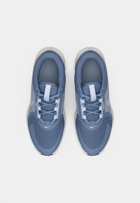 Plave Nike tenisice s mrežastom teksturom, zaobljenog oblika, ojačanim vrhom i ravnim vezicama. Svijetlosiva potplat i reflektirajući detalj loga.