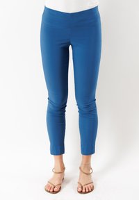 Leggings blu con una texture liscia, lunghezza a metà polpaccio e silhouette aderente, dotati di una semplice vita e senza ulteriori accessori.