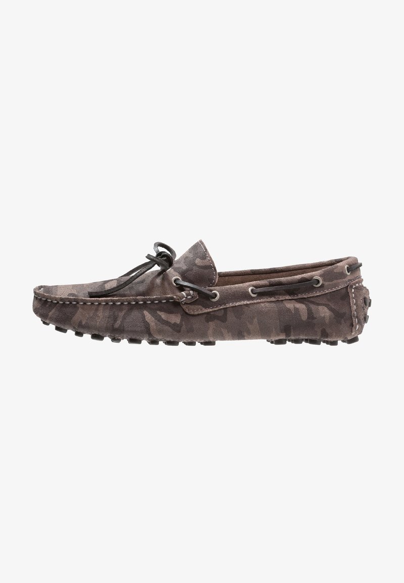 Mocassin loafer en suède marron avec un motif camouflage, détail de lacets et semelle en caoutchouc à pointes, présenté en profil latéral sur fond blanc.