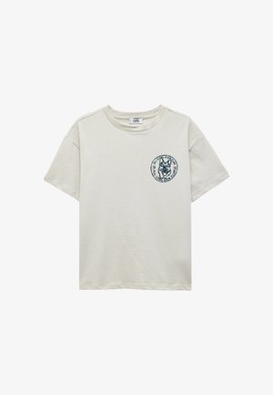Beige T-shirt met korte mouwen, ronde hals en een kleine cirkelvormige hondenlogo-print op de linkerborst met de tekst "All Cool Kids Club."