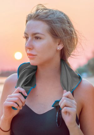 Cooling towel in gray with blue trim, worn around the neck. Smooth texture, lightweight fabric, suitable for outdoor activities at sunset.