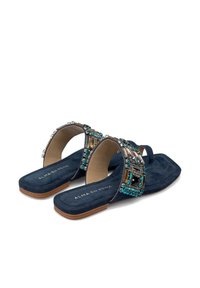 Sandalias planas de ante azul marino, con tiras decorativas de joyas con acentos en azul y plata, punta abierta y diseño de perfil bajo.
