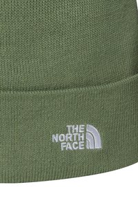 Beanie verde lavorato a maglia con bordo piegato, caratterizzato dal logo "The North Face" ricamato in bianco.