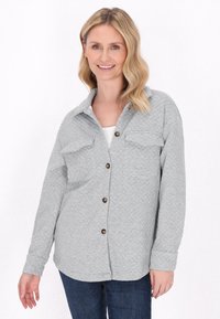 Giacca camicia trapuntata grigia con colletto, due tasche sul petto e bottoni marroni. Il tessuto presenta un motivo testurizzato e una vestibilità rilassata.