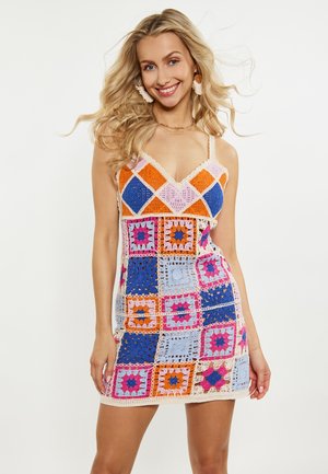 Gehaakte jurk met kleurrijke vierkanten in oranje, blauw, roze en lavendel. Spaghettibandjes en een golvende rand voegen detail toe.