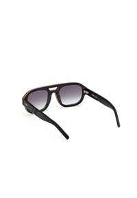 Mustat aurinkolasit, joissa on taitettavat linssit, suorakulmainen muoto, minimimäärä kultaisia yksityiskohtia kehykseen, ja uurrettuja sivuvarsia pitävyyskykyä varten.