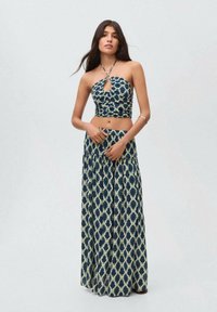 Strapless crop top and long skirt set in navy and cream ikat pattern. The top features a keyhole detail; the skirt has a gathered waist.