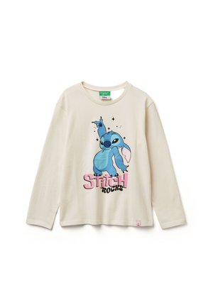 Maglietta a maniche lunghe di colore crema con grafica di un personaggio cartoon blu e la scritta "Stitch Rocks" in rosa e nero. Materiale in cotone leggero.