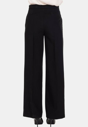 Pantaloni larghi neri con una texture liscia, dotati di una vita alta e tasche laterali, abbinati a tacchi per un look elegante.