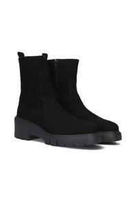 Black suede ankle boots feature a rounded toe, a side zipper, and a thick black rubber sole with textured treads for grip.