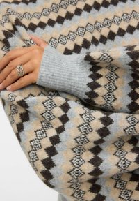 Strickpullover mit geometrischem Muster in Beige, Grau und Braun, mit gerippten grauen Bündchen und einer weichen, strukturierten Oberfläche.