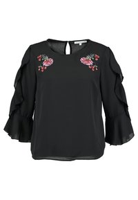 Blouse noire avec manches 3/4 à volants et broderie florale rose sur la poitrine près de l'encolure, dotée d'une fermeture au dos avec un bouton et une ouverture en trou de serrure.