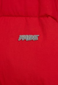 Czerwona kurtka puchowa z gładką teksturą i błyszczącym, srebrnym logo "FADE", wyraźnie widocznym z przodu.