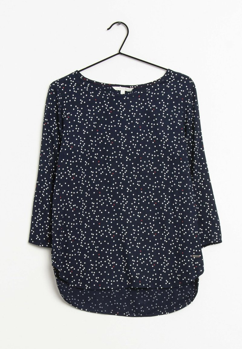 Haut à manches longues bleu marine avec des pois blancs et rouges, encolure ronde et ourlet arrondi. Fabriqué en tissu doux avec une coupe décontractée.