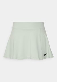 Falda acampanada verde menta con una cinturilla acanalada. Presenta un logo negro de Nike en la parte inferior izquierda. Tejido suave y ligero.
