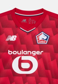 Röd fotbollströja med geometriskt mönster, New Balance- och LOSC Lille-logotyper, samt vit "boulanger" sponsortext på bröstet.
