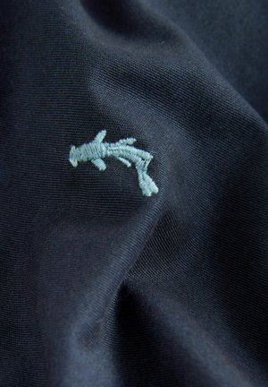 Marinefarvet stof med en struktureret overflade, der har et lille lyseblåt broderet grenmønster. Materialet fremstår blødt og glat.