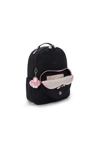 Mochila negra con superficie texturizada, detalles en cremallera rosa y un bolsillo frontal. Presenta un llavero de felpa rosa adjunto.