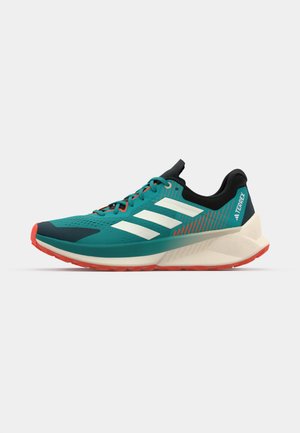 Turquoise athletic shoe with white stripes, black accents, and red outsole. Features textured surface and ventilated design for breathability.