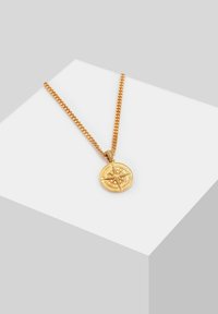 Collana tono oro con pendente rotondo decorato con un motivo a bussola, montata su una catena spessa. Texture liscia, linee pulite e dettagli minimi.