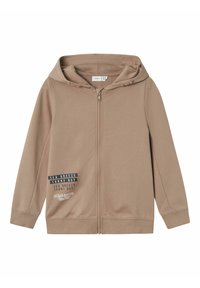 Felpa con zip di colore beige realizzata in materiale morbido. Presenta un cappuccio con cordino, maniche lunghe e una grafica stampata sul lato sinistro.