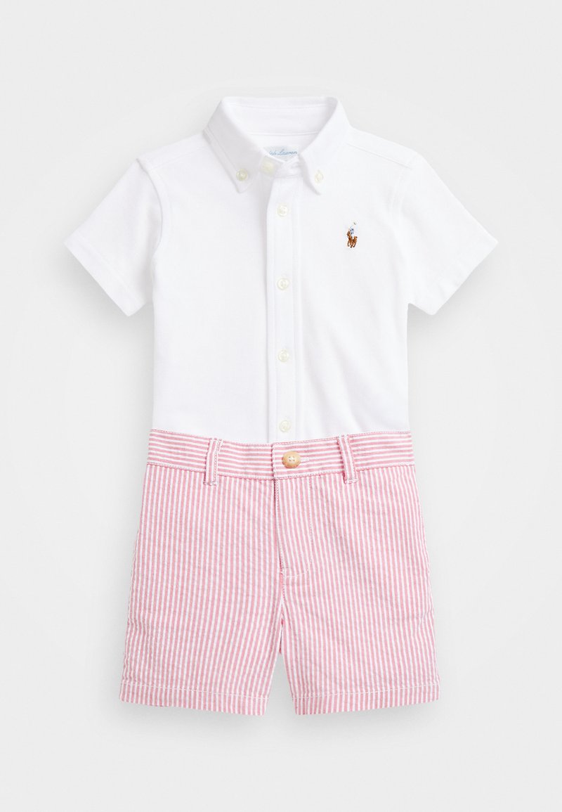 Camisa polo branca de manga curta com casa de botão e logótipo bordado; combinada com calções às riscas vermelhas e brancas com fecho de botão.